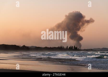 Paysage côtier de coucher de soleil avec champ de canne à sucre brûlant de la fumée à Brunswick Heads, près de Byron Bay, Nouvelle-Galles du Sud - Une fusion unique de beauté naturelle a Banque D'Images