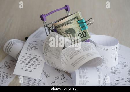Un tas de dollars AMÉRICAINS dans un chariot entouré de nombreux reçus en papier se rapprochent Banque D'Images