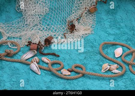 Fond bleu profond avec coquillages, corde et filet de poisson Banque D'Images