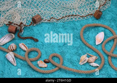 Fond bleu profond avec coquillages, corde et filet de poisson Banque D'Images