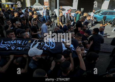 10 novembre 2023 : Jénine, Cisjordanie, Palestine. 15 novembre 2023. Le cercueil d'un palestinien tué lors du raid israélien de jeudi sur le camp de réfugiés de Cisjordanie de Djénine est couvert par un drapeau du Jihad islamique lors d'un enterrement à Djénine. 15 Palestiniens ont été tués et 20 autres blessés lors de l'assaut israélien contre le camp. Les forces israéliennes ont utilisé des drones et des bulldozers en plus de véhicules blindés. L’armée israélienne mène des raids nocturnes constants à travers la Cisjordanie depuis un an et demi, mais les raids se sont encore intensifiés depuis octobre 7 (crédit im Banque D'Images