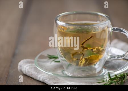 thé chaud sur table en bois. Tasse transparente de thé fraîchement infusé sur la table en bois, concept sain de boisson Banque D'Images