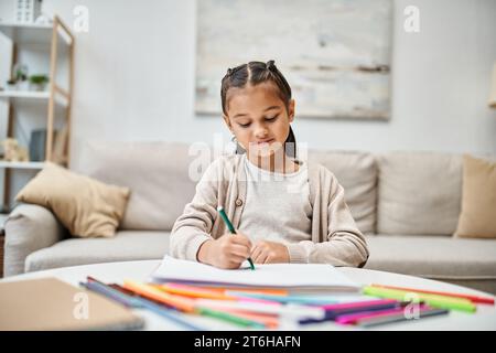 portrait de dessin de fille d'âge élémentaire avec crayon de couleur dans un appartement moderne, de loisirs et d'art. Banque D'Images