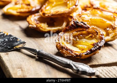 Mini-tartes faites de pâte feuilletée et de pommes tranchées sur une planche à découper. Gâteaux aux pommes France - gros plan. Banque D'Images