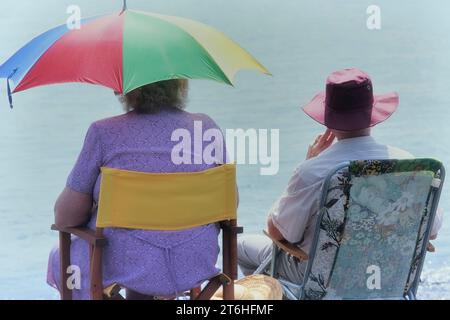 Deux retraités assis dans des chaises pliantes le long du front de mer à Southend-on-Sea. Southend, Essex. Angleterre. ROYAUME-UNI Banque D'Images