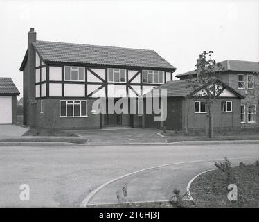 Fin des années 1970, historique, maison d'exposition détachée sur un nouveau lotissement, Angleterre, Royaume-Uni, construit dans un style «simulé-tudor», avec des panneaux extérieurs de type faux bois. Cette conception, de plus grandes maisons dites exécutives était populaire dans les années 70 et 80, souvent construites sur des mini-domaines, ce qui signifie que trop de maisons ont été pressées dans des parcelles toos petits pour la taille de la maison, souvent sur une maison avec de grands jardins qui avait été démolie. Banque D'Images