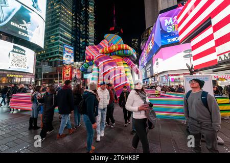 Les touristes affluent « Sculpture of Dreams », de l’artiste conceptuelle Marta Minujin à Times Square à New York le mercredi 8 novembre 2023. Présentée par Times Square Arts avec le Musée juif, la pièce gonflable de 16 est, selon les mots de Minujin, une « anti-sculpture » et est en conjonction avec une exposition de son travail au Musée juif. La maquette de la bulle sera exposée jusqu'au 21 novembre. (© Richard B. Levine) Banque D'Images