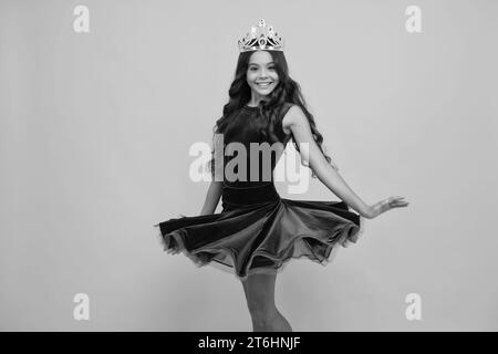 Robe venteuse mouvement. Petite reine portant une couronne dorée. Adolescente princesse tenant tiara couronne. PROM partie, concept d'enfance. Bonne fille visage Banque D'Images