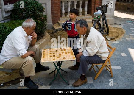 Chine, Shanghai, ancien ghetto juif Hongkou Duolun lu. Scène de rue ; hommes jouant à des jeux Banque D'Images