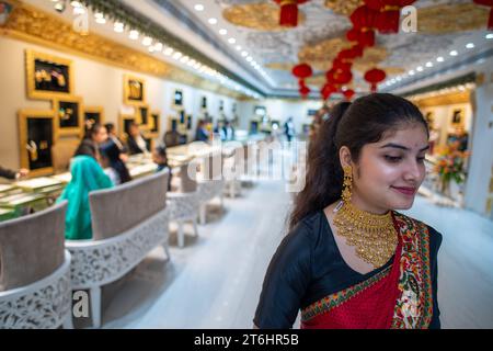 New Delhi, Inde. 10 novembre 2023. Une vendeuse présentant des bijoux à l'occasion de Dhanteras chez P.P. Jewellers by Pawan Gupta showroom dans South extension Market. Sur Dhanteras, il est une tradition commune pour les gens, en particulier en Inde, d'acheter de l'or, de l'argent ou d'autres métaux précieux et ustensiles. Cette pratique est considérée comme auspicieuse et est censée apporter prospérité et chance. Crédit : SOPA Images Limited/Alamy Live News Banque D'Images