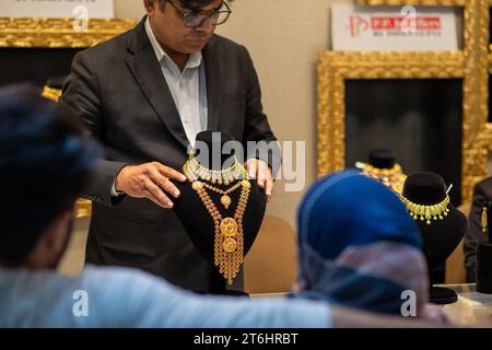 New Delhi, Inde. 10 novembre 2023. Un vendeur montrant des bijoux aux consommateurs à l'occasion de Dhanteras chez P.P. Jewellers by Pawan Gupta showroom dans South extension Market. Sur Dhanteras, il est une tradition commune pour les gens, en particulier en Inde, d'acheter de l'or, de l'argent ou d'autres métaux précieux et ustensiles. Cette pratique est considérée comme auspicieuse et est censée apporter prospérité et chance. Crédit : SOPA Images Limited/Alamy Live News Banque D'Images