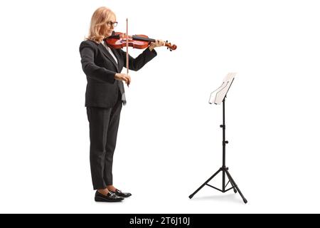 Plan complet d'une femme jouant du violon et lisant des feuilles de musique isolées sur fond blanc Banque D'Images