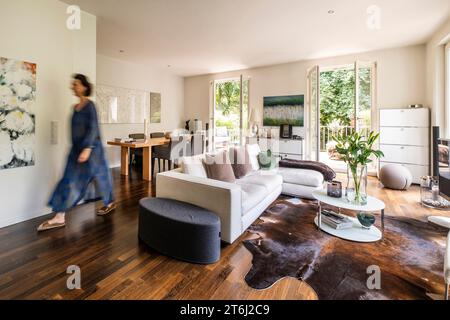 Femme dans un appartement moderne dans le salon - salle à manger Banque D'Images