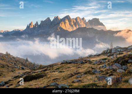 Italie, Vénétie, quartier de Belluno, Falcade, coucher de soleil d'automne avec un faible brouillard sur la vallée et vue sur le côté nord de la Pale di San Martino du mont Pradazzo, Dolomites Banque D'Images