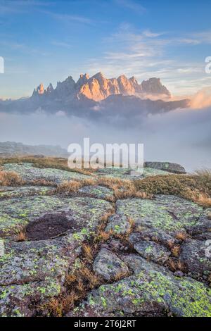 Italie, Vénétie, quartier de Belluno, Falcade, coucher de soleil d'automne avec un faible brouillard sur la vallée et vue sur le côté nord de la Pale di San Martino du mont Pradazzo, Dolomites Banque D'Images