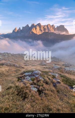 Italie, Vénétie, quartier de Belluno, Falcade, coucher de soleil d'automne avec un faible brouillard sur la vallée et vue sur le côté nord de la Pale di San Martino du mont Pradazzo, Dolomites Banque D'Images