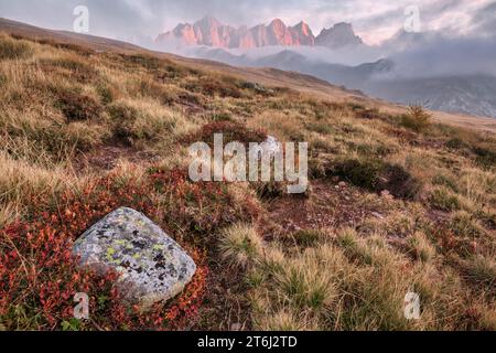 Italie, Vénétie, quartier de Belluno, Falcade, coucher de soleil d'automne avec un faible brouillard sur la vallée et vue sur le côté nord de la Pale di San Martino du mont Pradazzo, Dolomites Banque D'Images