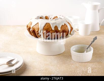 Gâteau à la citrouille bundt arrosé d'un glaçage au sucre en poudre sur un support à gâteau Banque D'Images