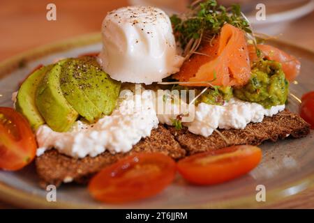 Fromage cottage, avocat et craquelin de saumon fumé avec oeuf poché sur le dessus Banque D'Images