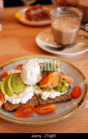 Fromage cottage, avocat et craquelin de saumon fumé avec oeuf poché sur le dessus Banque D'Images