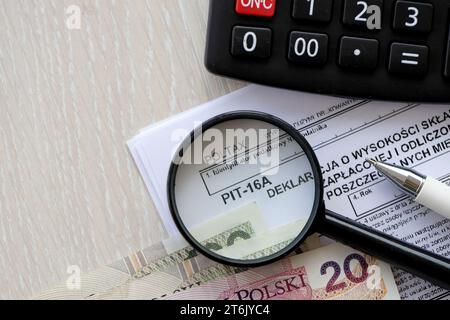 Déclaration du montant des cotisations d'assurance maladie payées et déduites de la carte d'impôt dans les mois individuels de l'année d'imposition, formulaire PIT-16a sur la table comptable avec stylo et factures d'argent zloty poli Banque D'Images