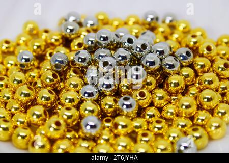 Perles d'argent sur perles dorées pour faire des colliers et des bracelets Banque D'Images