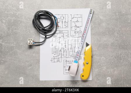 Schéma de câblage, fils et outils sur table grise, vue de dessus Banque D'Images