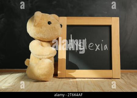 Ours en peluche et petit tableau noir avec mot Dyslexia sur la table en bois Banque D'Images