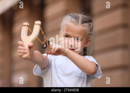 Petite fille jouant avec la fronde sur la rue de la ville Banque D'Images