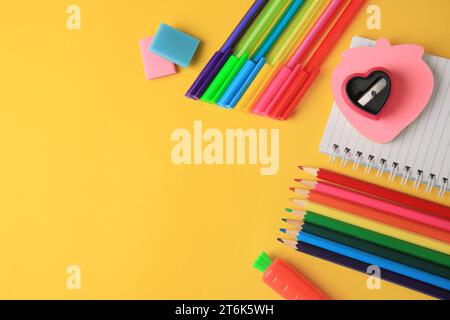 Composition de la pose plate avec différentes fournitures scolaires sur fond jaune, espace pour le texte. Retour à l'école Banque D'Images