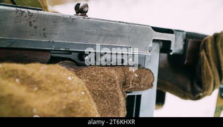 Soldat américain avec Old Thompson Sub-mitrailleuse. Gros plan Voir détail sur Thompson Sub-mitrailleuse dans les mains de Re-Enactor habillé en infanterie américaine Banque D'Images