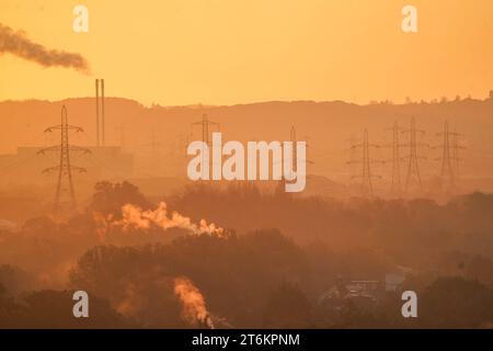 Londres, Royaume-Uni. 11 novembre 2023. Tours de transmission électriques à Wimbledon, sud-ouest de Londres sont silhouettés contre un ciel orange vif au lever du soleil sur un matin d'automne froid et givré crédit : amer ghazzal/Alamy Live News Banque D'Images