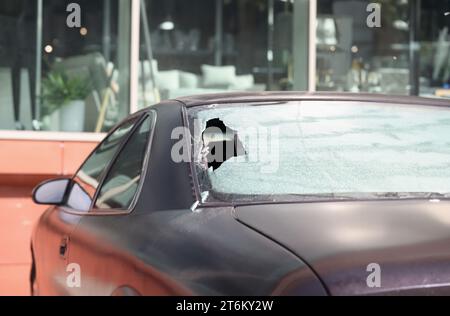 Gros plan de la lunette arrière cassée d'une voiture noire Banque D'Images