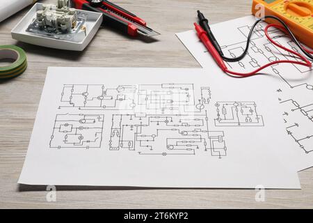 Schémas de câblage et multimètre numérique sur table en bois blanc, gros plan Banque D'Images