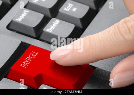 Femme appuyant sur le bouton rouge avec le mot paie sur le clavier, gros plan Banque D'Images