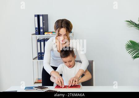 un garçon avec un psychologue dans le bureau joue à des jeux de société Banque D'Images