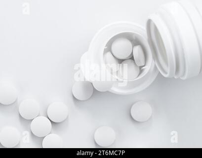 Vue de dessus des pilules blanches en bouteille blanche avec espace de copie. Banque D'Images