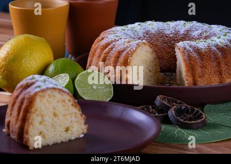 tranche de gâteau au citron et le reste du gâteau en arrière-plan. Banque D'Images