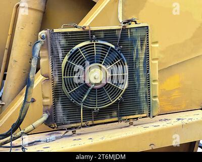 Vieux ventilateur de radiateur d'excavatrice jaune rouillé utilisé. Détails sur les technologies industrielles Banque D'Images