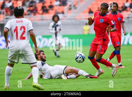 (231111) -- JAKARTA, 11 nov. 2023 (Xinhua) -- Jayden Meghoma (R) d'Angleterre concourt avec Inine Huna de Nouvelle-Calédonie lors du match du groupe C de la coupe du monde U-17 de la FIFA, Indonésie 2023 à Jakarta, Indonésie, le 11 novembre 2023. (Xinhua/Zulkarnain) Banque D'Images