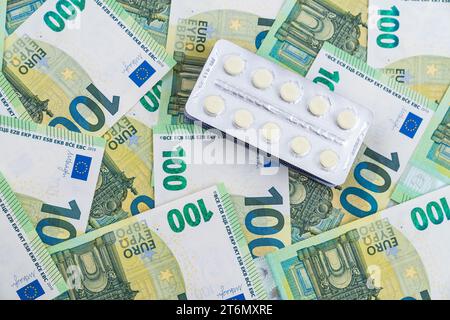 Vue de dessus sur les blisters avec des pilules sur les billets d'euro comme arrière-plan. Coût élevé du concept de fournitures médicales. Photo de haute qualité Banque D'Images