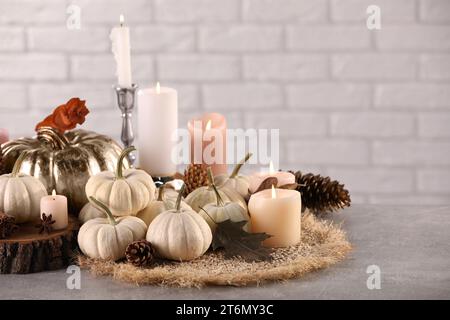 Belle composition avec des citrouilles et des bougies allumées sur la table Banque D'Images