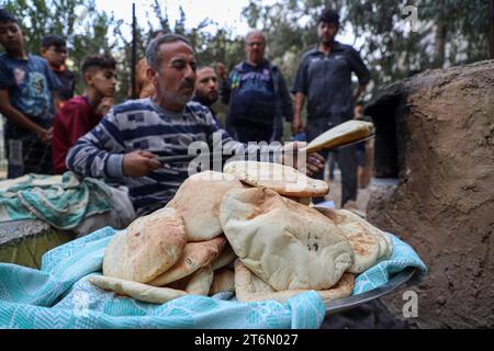 Gaza. 11 novembre 2023. Un volontaire prépare du pain pour les Palestiniens déplacés dans la ville de Khan Younis, dans le sud de la bande de Gaza, le 11 novembre 2023. Le nombre de morts palestiniens à Gaza a dépassé 11 000 depuis que le conflit israélo-Hamas a éclaté le 7 octobre, a annoncé vendredi le ministère de la Santé de Gaza. Crédit : Rizek Abdeljawad/Xinhua/Alamy Live News Banque D'Images