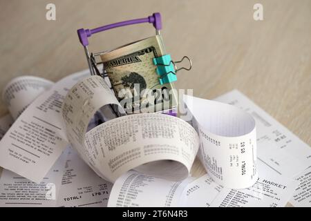 Un tas de dollars AMÉRICAINS dans un chariot entouré de nombreux reçus en papier se rapprochent Banque D'Images