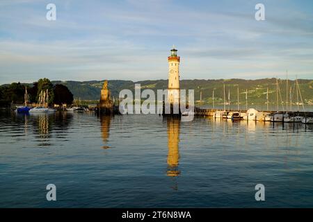 Port ensoleillé et balise de Lindau sur le lac tranquille Constance (lac Bodensee) avec les Alpes en arrière-plan sur une soirée ensoleillée et chaude en octobre Banque D'Images