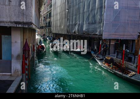 Venise, Italie. Touristes à cheval en gondole à un canal explorant la ville de Venise. Banque D'Images