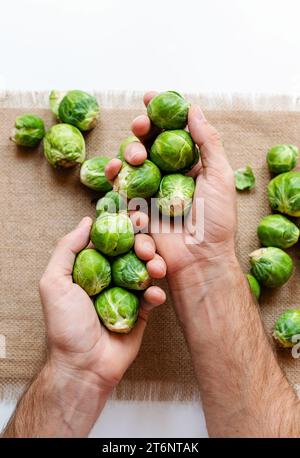 Manger sainement. Des choux de Bruxelles dans des mains masculines rapprochées. Nourriture végétarienne. Banque D'Images