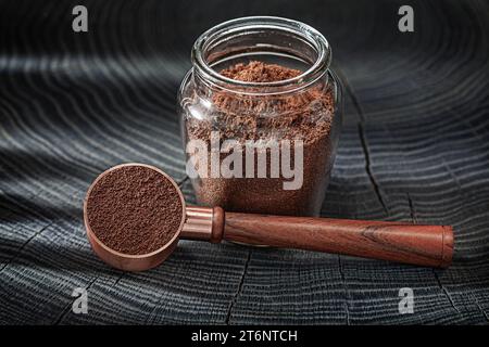 Café moulu dans un pot en verre et cuillère avec poignée en bois Banque D'Images