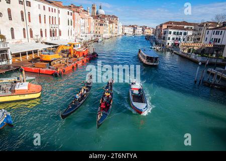 Venise, Italie. Touristes à cheval en gondole au Grand Canal explorant la ville de Venise. Banque D'Images