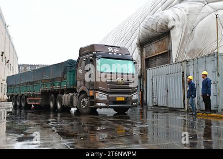 YANTAI, CHINE - 11 NOVEMBRE 2023 - Un membre du personnel d'une société de chauffage demande à un transporteur de charbon d'entrer dans un hangar de charbon pour décharger du charbon à Yantai, dans la province du Shandong, en Chine, le 11 novembre 2023. (Photo de Costfoto/NurPhoto) Banque D'Images